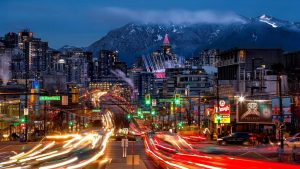 Cityscape at dusk showcasing vibrant traffic lights and illuminated buildings, with mountains in the background, representing Blaze Signs' commitment to quality signage and graphics in urban settings.